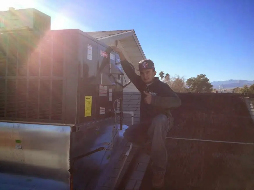 HVAC technician performing Air Duct Repair on a rooftop unit in Groveland